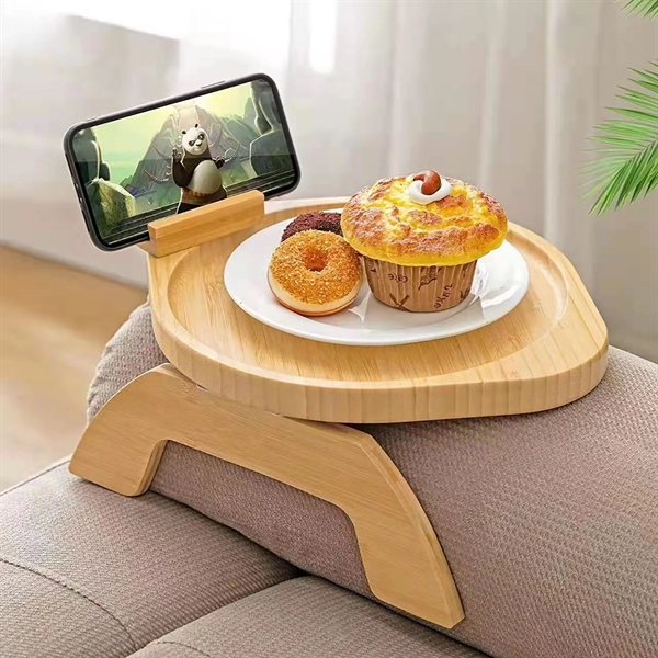 Bamboo Sofa Armrest Tray Desk sitting on couch and holding a plate of food and mobile device
